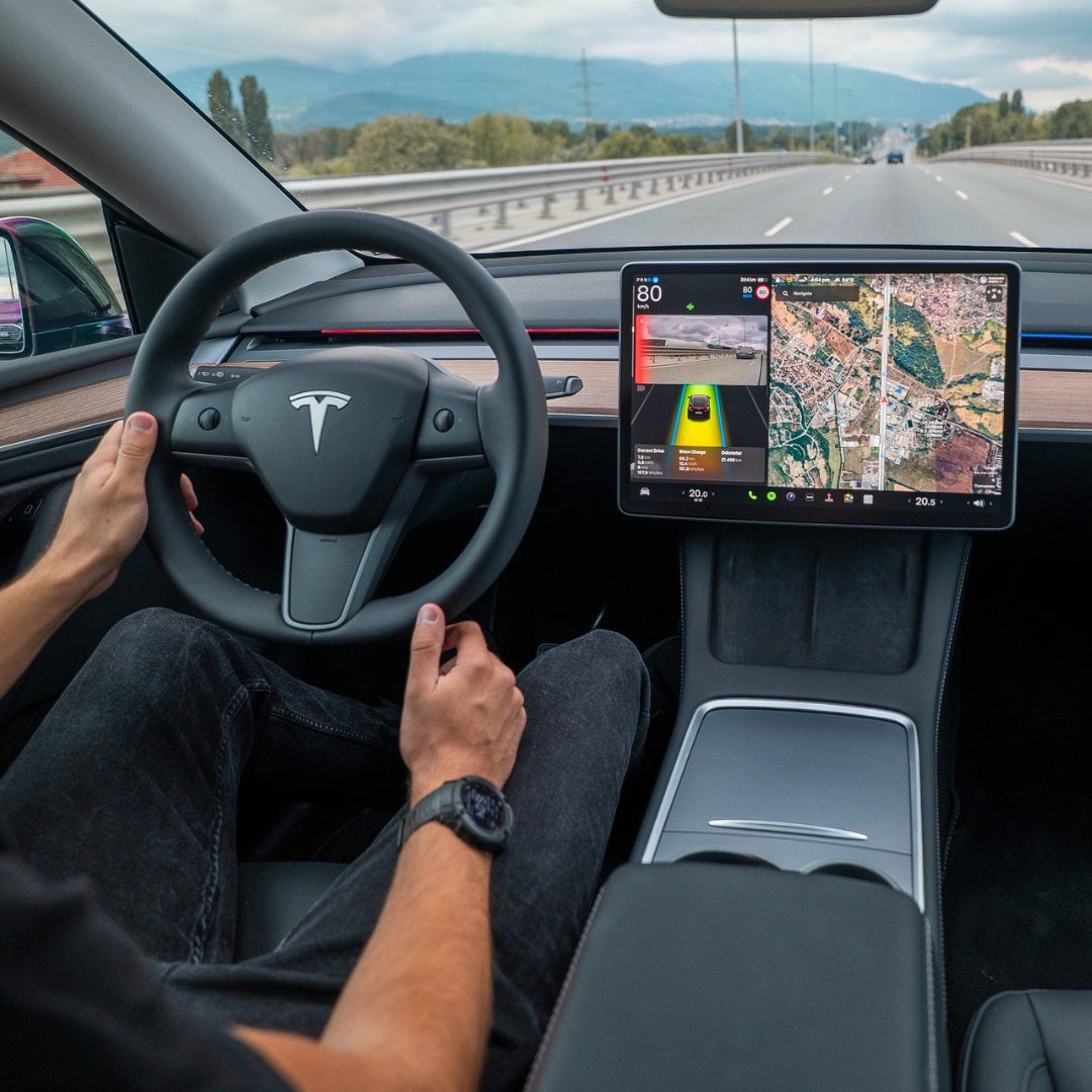 Tesla interior with a driver at the wheel, touchscreen navigation and red S3XY Strip dashboard lighting.