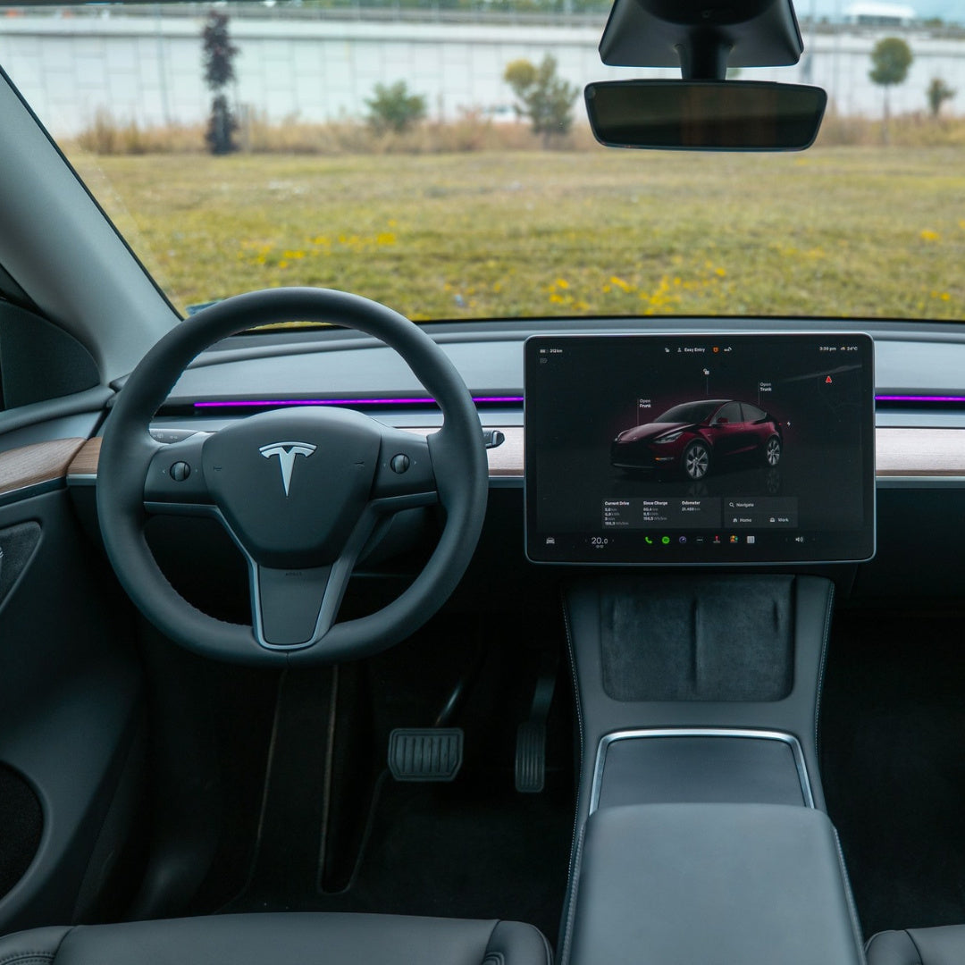 Tesla interior with purple S3XY Strip ambient lighting across the dashboard above the wood-effect trim.
